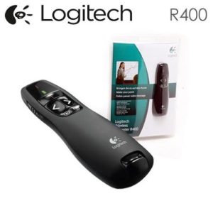 A Logitech R400 presenter remote, featuring a sleek black design with intuitive buttons for slide navigation. The remote is positioned on a white surface, with its USB receiver plugged into a laptop. The laser pointer is activated, highlighting key points on a presentation screen."